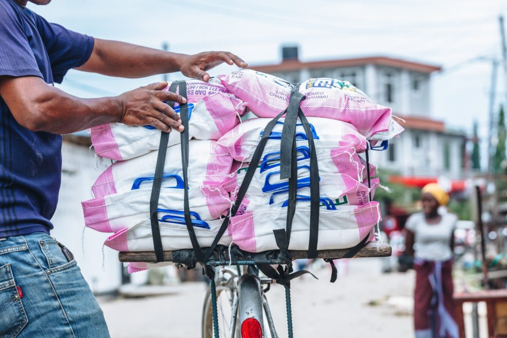 photo of man with bike with stacks of flour bags